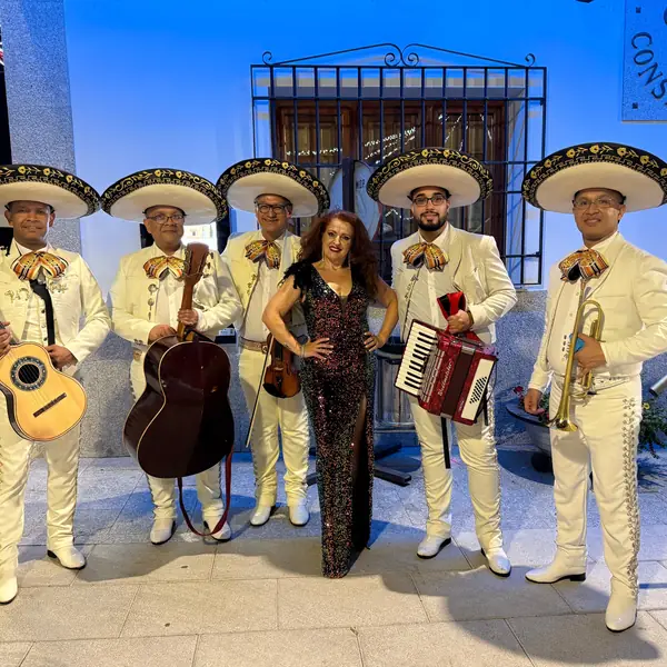 Mariachis en Madrid con traje blanco en un evento nocturno