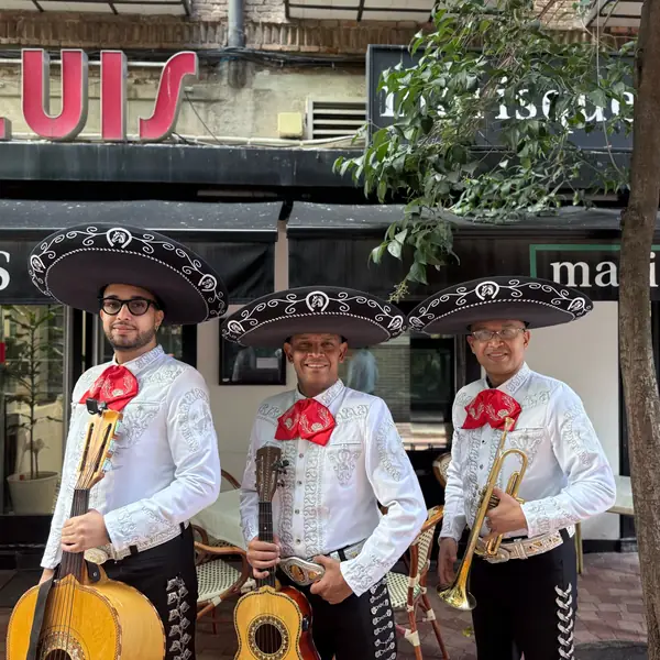 Mariachis en Madrid con camisa blanca tocando en un restaurante
